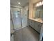 A main bathroom with a glass shower, tile floors, and double sink vanity with a large mirror at 308 White Oak Garden Way # 215, Garner, NC 27529