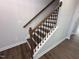 Elegant staircase featuring hardwood steps, white risers, and stylish black iron balusters at 308 White Oak Garden Way # 215, Garner, NC 27529