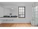 Bright bathroom with a double sink vanity, large window, and wood flooring at 312 N Buchanan Blvd # 302, Durham, NC 27701