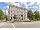 Classic multi-story apartment building featuring yellow brick, mature trees, and professional landscaping at 312 N Buchanan Blvd # 302, Durham, NC 27701