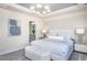 Well-lit main bedroom featuring a plush upholstered bench and ensuite bathroom at 3412 Pelican Ln, Durham, NC 27703