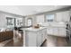 Bright open kitchen with white cabinets, hardwood floors, island, stainless steel faucet, and dining area at 345 Broomside Ave, Raleigh, NC 27603