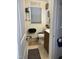 Cozy bathroom with toilet, vanity, window with blinds, and decorative wall art at 3607 Buffaloe Rd, Raleigh, NC 27604