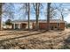 Brick house with a well-maintained backyard, featuring mature trees for shade and lawn at 3639 Nc Highway 39, Selma, NC 27576