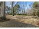 A large, grassy backyard surrounded by mature trees with lots of space at 3639 Nc Highway 39, Selma, NC 27576
