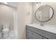 Bright bathroom featuring a modern vanity with sink, round mirror, toilet, and walk-in shower at 3639 Nc Highway 39, Selma, NC 27576