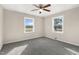 Bedroom featuring wood-look paneling, two large windows and a ceiling fan at 3639 Nc Highway 39, Selma, NC 27576