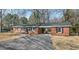 Charming red brick home featuring a gravel driveway, covered carport, and nicely trimmed landscaping at 3639 Nc Highway 39, Selma, NC 27576