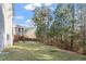 Scenic backyard view showcasing a screen porch and a wooded area beyond the green lawn at 401 River Falls Dr, Apex, NC 27539
