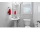 Well-lit powder room featuring a pedestal sink, modern fixtures, and a large window for ample natural light at 401 River Falls Dr, Apex, NC 27539