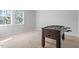This bedroom has neutral colored walls, one window, and neutral carpet with foosball table at 401 River Falls Dr, Apex, NC 27539