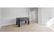 This bedroom has neutral colored walls, and neutral carpet with foosball table at 401 River Falls Dr, Apex, NC 27539