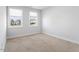 This bedroom has neutral colored walls, two windows, and neutral carpet at 401 River Falls Dr, Apex, NC 27539