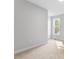 Neutral bedroom features a large window and carpeted floors at 401 River Falls Dr, Apex, NC 27539