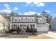 Charming two-story home features a covered front porch, manicured lawn, and attached two-car garage at 401 River Falls Dr, Apex, NC 27539
