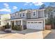 Charming two-story home features a covered front porch, manicured lawn, and attached two-car garage at 401 River Falls Dr, Apex, NC 27539