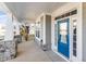 Close-up of a front porch with stone accents, columns, and a blue front door at 401 River Falls Dr, Apex, NC 27539