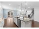 Kitchen island with granite counter tops, stainless steel appliances, and view to living room at 401 River Falls Dr, Apex, NC 27539