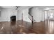 Spacious living room with hardwood flooring, fireplace, and staircase at 401 River Falls Dr, Apex, NC 27539