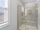 Bathroom shower with tiled walls, glass enclosure, and built-in shower seat at 401 River Falls Dr, Apex, NC 27539