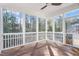 Sunroom with hardwood floors and glass pane windows, creating a cozy and bright space at 401 River Falls Dr, Apex, NC 27539