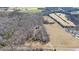 Scenic aerial view of a secluded property surrounded by trees and open fields at 4639 Reid Rd, Elon, NC 27244