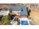 Aerial view of a brick home with a covered pool, patio, and meticulously kept grounds in a wooded setting at 4639 Reid Rd, Elon, NC 27244