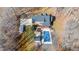 Aerial view of home with brick exterior, covered pool and pool house, and long driveway at 4639 Reid Rd, Elon, NC 27244
