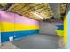 Unfinished basement with painted concrete floor and colorful painted walls and exposed ceiling at 4639 Reid Rd, Elon, NC 27244
