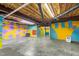 Unfinished basement features painted concrete floor and colorful painted walls at 4639 Reid Rd, Elon, NC 27244