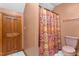 Bathroom featuring a colorful shower curtain, a toilet, and a wood-look door at 4639 Reid Rd, Elon, NC 27244