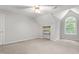 An empty bedroom featuring a window with natural light, a ceiling fan, and an alcove with shelving at 4639 Reid Rd, Elon, NC 27244