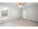 A bright bedroom features neutral walls and carpet, a ceiling fan, and a window with natural light at 4639 Reid Rd, Elon, NC 27244