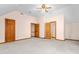 Spacious bedroom featuring neutral carpeting, ceiling fan, and multiple wooden doors at 4639 Reid Rd, Elon, NC 27244