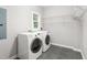 Bright laundry room features shelving, tile flooring, and modern washer and dryer units at 4639 Reid Rd, Elon, NC 27244
