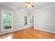 Bright living room with hardwood floors, ceiling fan, and natural light from the surrounding landscape at 4639 Reid Rd, Elon, NC 27244