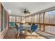 Screened-in porch featuring a wood floor, dining table, and ceiling fan with wooded views at 4639 Reid Rd, Elon, NC 27244