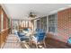 Screened-in porch with wood floor, dining table set, ceiling fan, and brick exterior at 4639 Reid Rd, Elon, NC 27244
