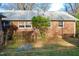 Brick house featuring a serene backyard with stone pathway and mature landscaping offering privacy at 610 Westbrook Dr, Burlington, NC 27215
