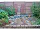 Tranquil backyard featuring a decorative water feature, stone accents, and lush greenery at 610 Westbrook Dr, Burlington, NC 27215