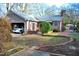 View of the backyard showcasing an attached garage and charming brick-lined garden at 610 Westbrook Dr, Burlington, NC 27215