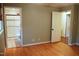 Bedroom with neutral walls and hardwood floors; ensuite bathroom with glass-enclosed shower at 610 Westbrook Dr, Burlington, NC 27215