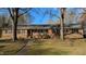Charming brick home featuring a welcoming front porch, mature trees, and a well-maintained lawn at 610 Westbrook Dr, Burlington, NC 27215