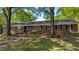 Charming single-story brick home featuring a well-manicured lawn and mature trees at 610 Westbrook Dr, Burlington, NC 27215