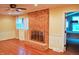 Bright living room showcasing a brick fireplace, hardwood floors, and abundant natural light through the windows at 610 Westbrook Dr, Burlington, NC 27215