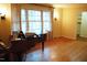 Cozy living room featuring a baby grand piano, light hardwood floors and large windows with natural light at 610 Westbrook Dr, Burlington, NC 27215