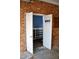 Open view of a storage area in a garage, featuring shelving and a brick background at 610 Westbrook Dr, Burlington, NC 27215