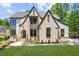 Beautiful two-story home featuring a brick facade, arched entryway, and manicured lawn at 7621 Wingfoot Dr, Raleigh, NC 27615