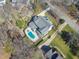 An aerial view of an estate home with a swimming pool and beautifully landscaped lawns and hardscapes at 7621 Wingfoot Dr, Raleigh, NC 27615