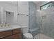 Bathroom with wood vanity, toilet, and glass shower with bench and light blue tile at 7621 Wingfoot Dr, Raleigh, NC 27615